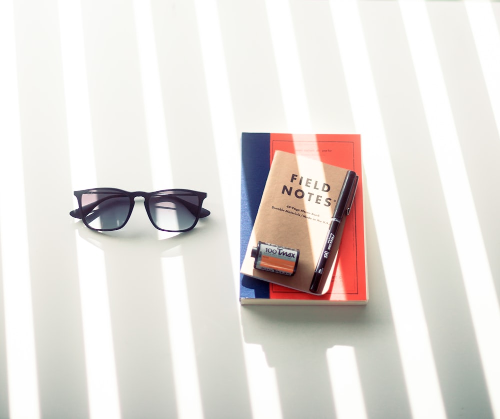 black framed sunglasses on white table