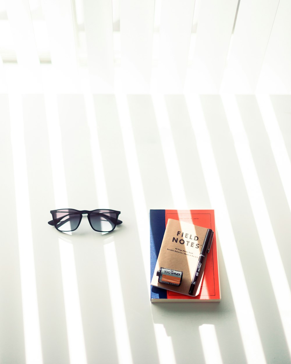 black framed sunglasses on red book