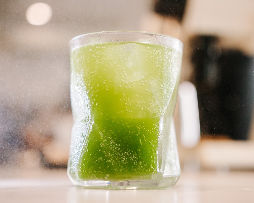 green liquid in clear drinking glass