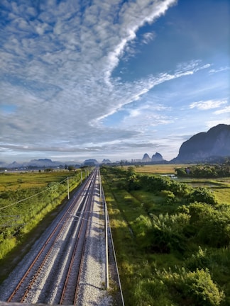 Railway infrastructure with tracks stretching into the horizon framed by rolling hills