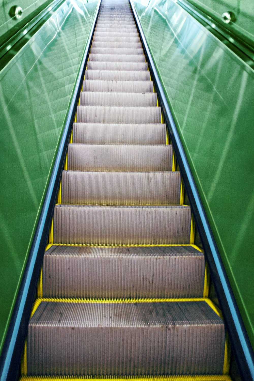 brown and gray staircase with green metal railings