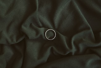 silver ring on black textile
