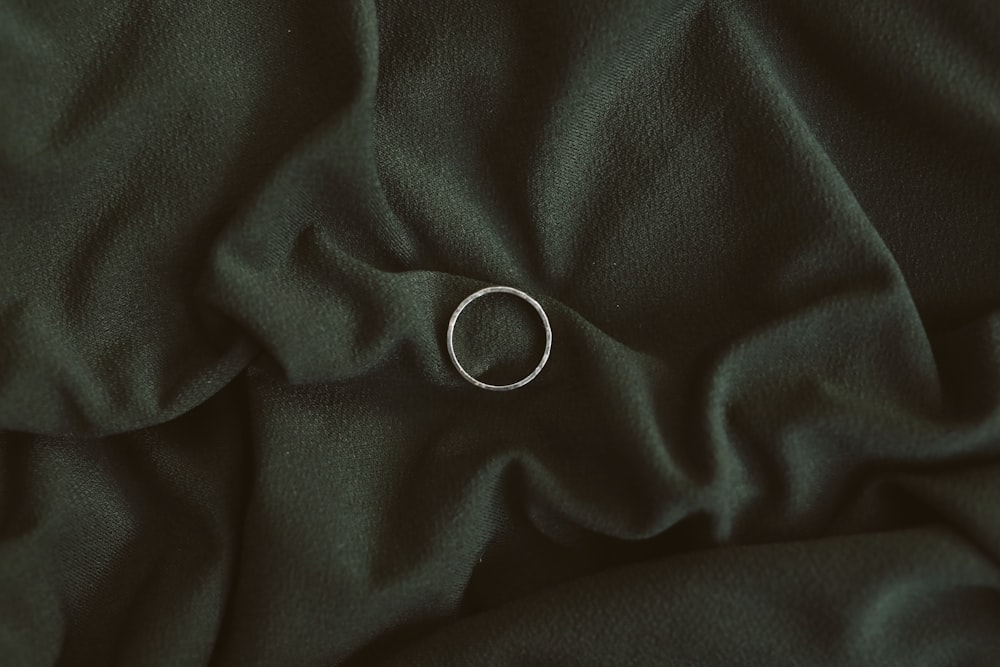 silver ring on black textile