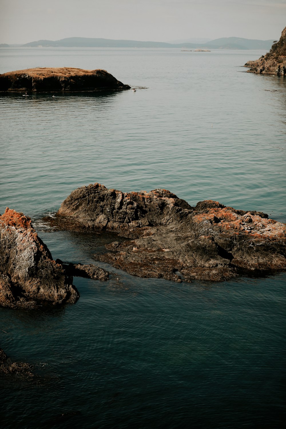 brown rock formation on body of water during daytime