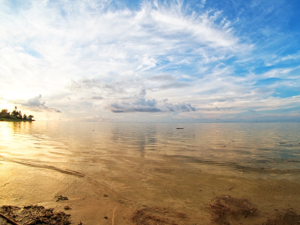 sea under blue sky and white clouds during daytime