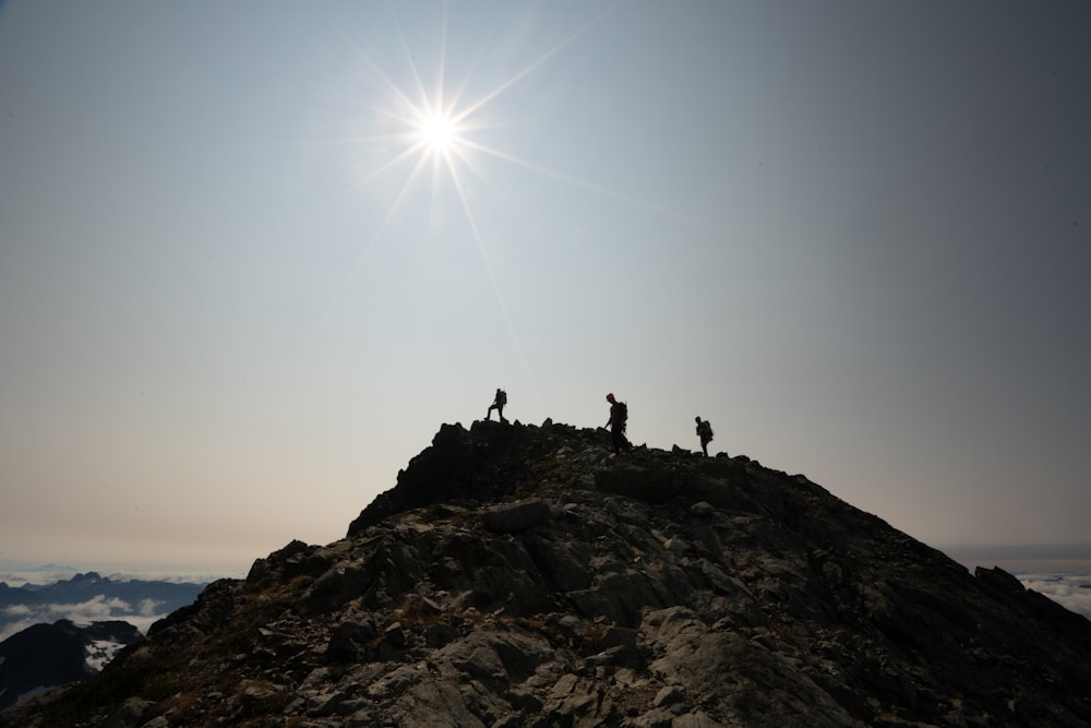 silhouette of person standing on rock formation during daytime