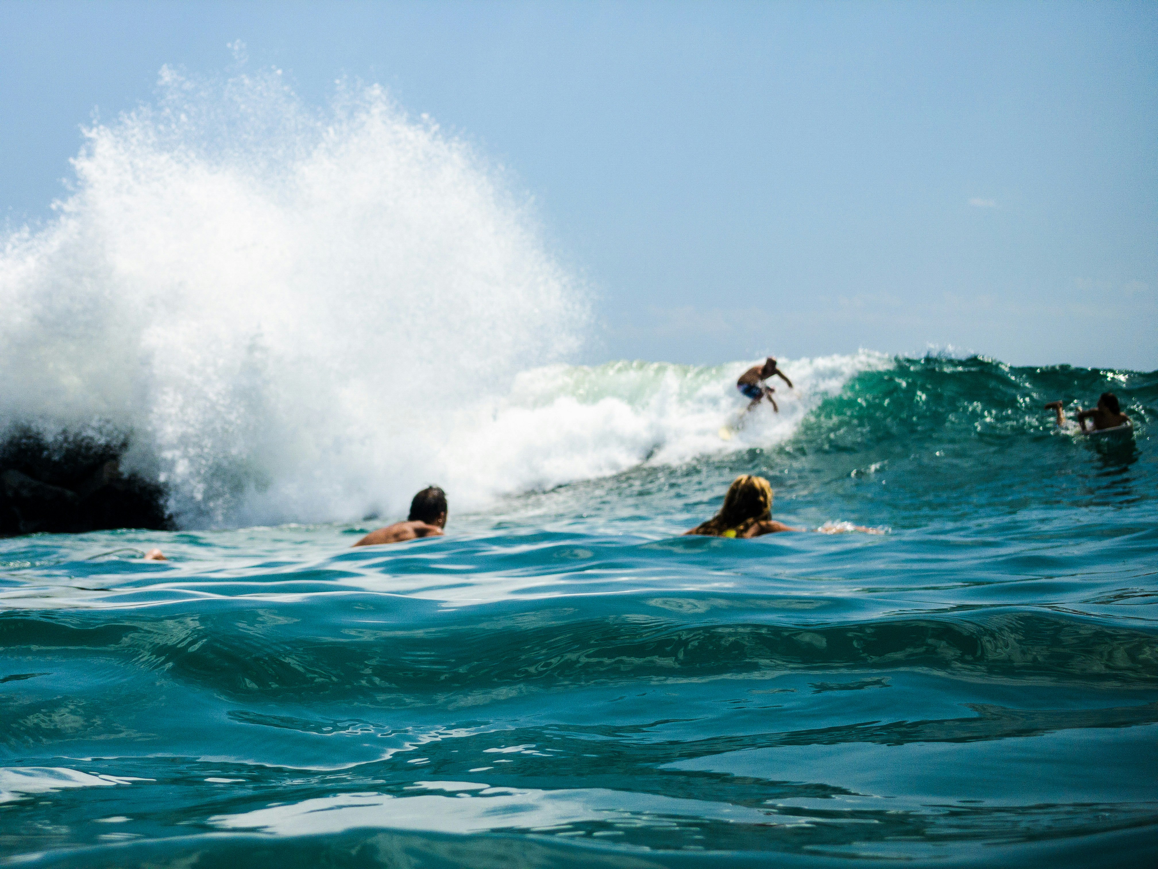 man surfing on sea waves during daytime