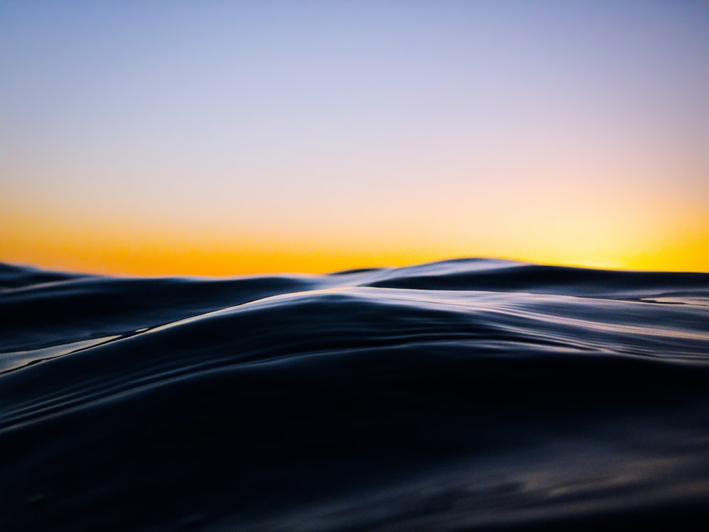 black sand under orange sky during sunset