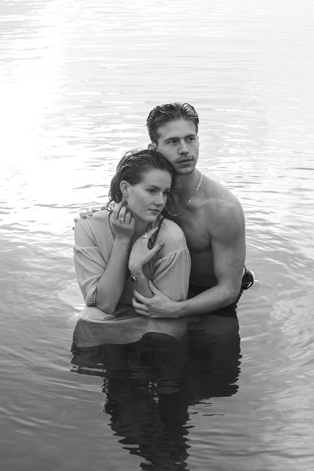 grayscale photo of man and woman on water