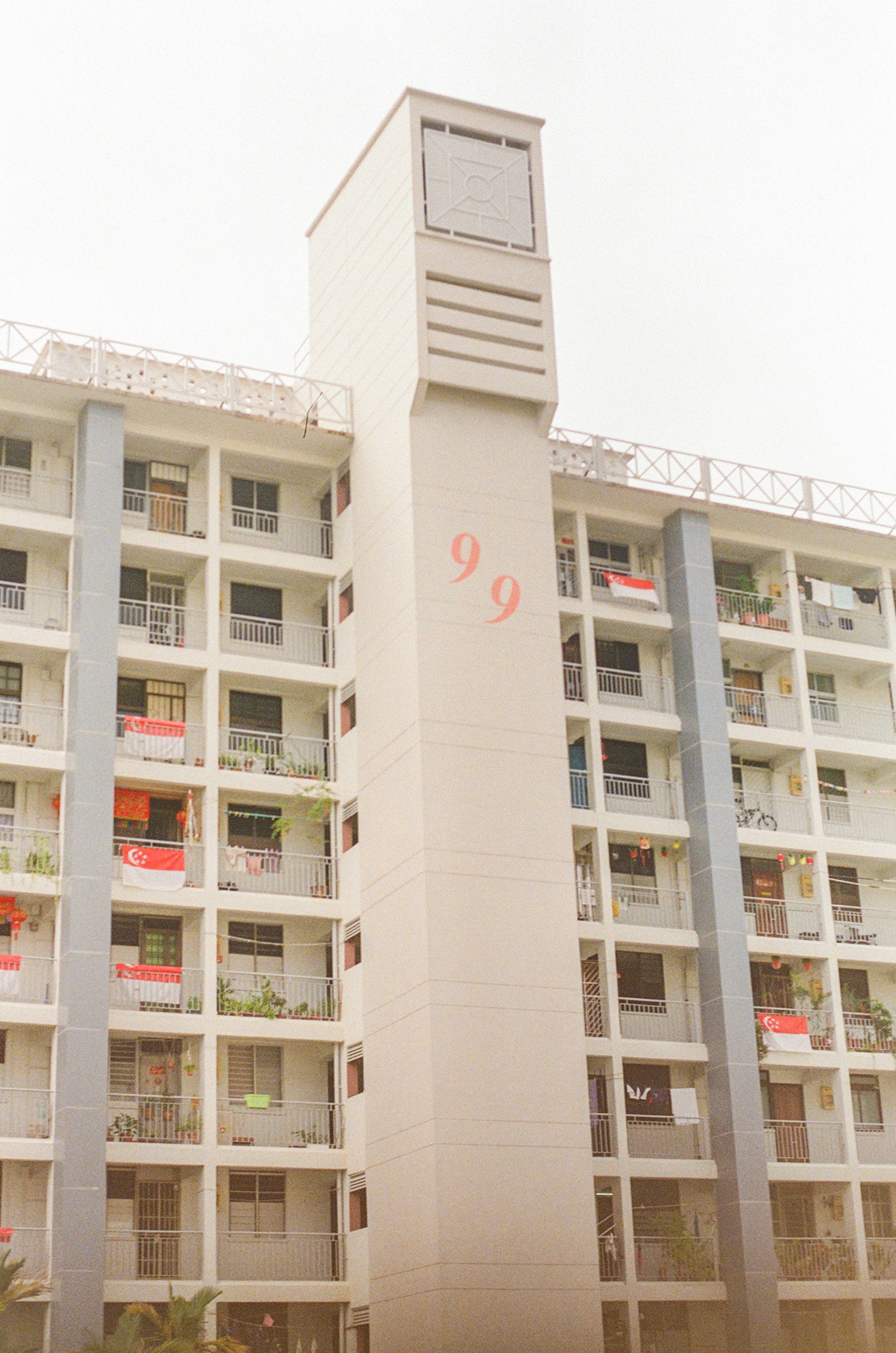 white concrete building with red and white windows