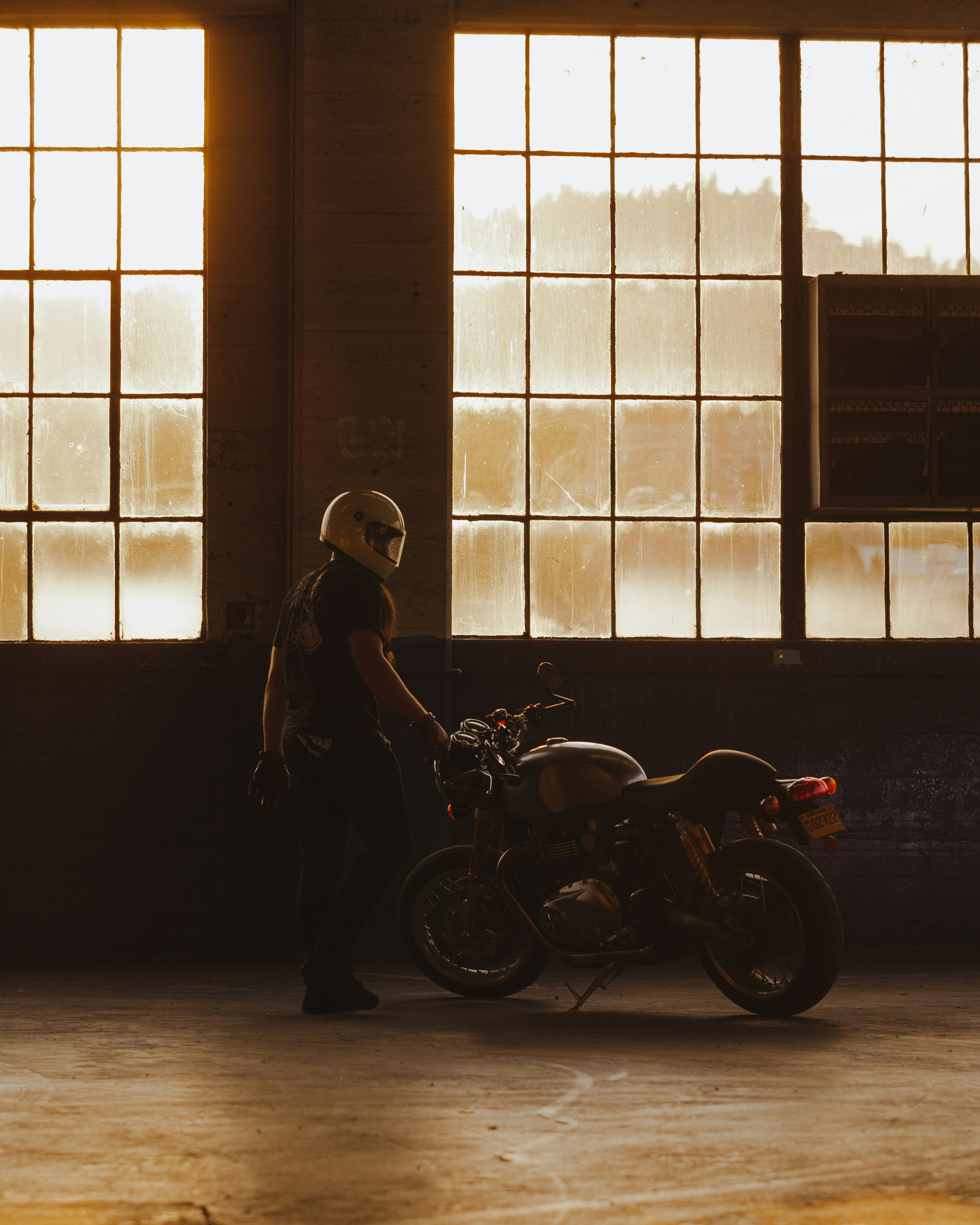 woman in black coat standing beside motorcycle