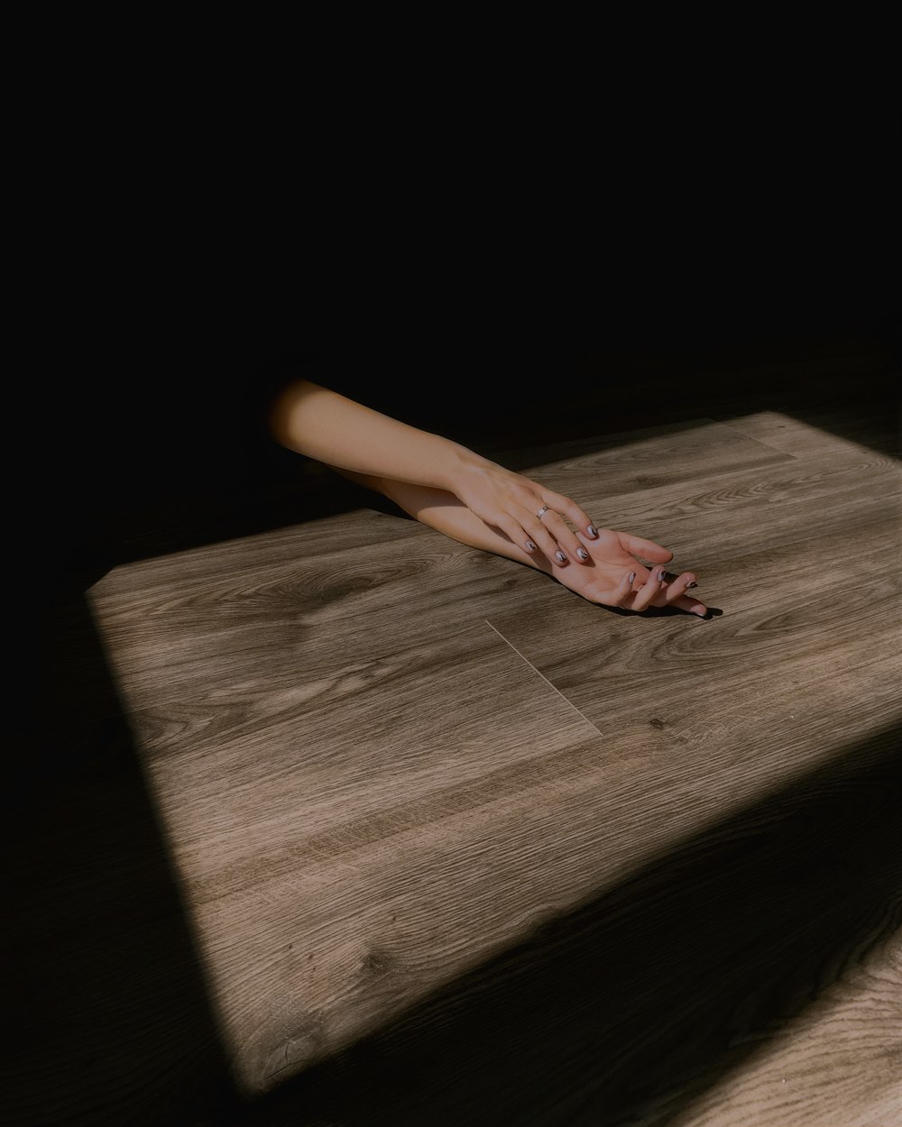persons hand on brown wooden table
