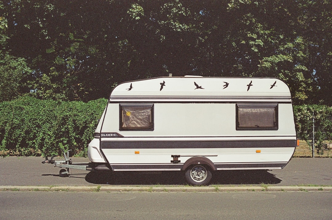 white and brown rv trailer parked on gray asphalt road during daytime, CARAVAN OF LOVE. Made with Leica R7 (1994) and Summilux-R 1.4 50mm (1983). Hi-Res analog scan by: www.totallyinfocus.com – Kodak SO-553 100 (expired 2003)