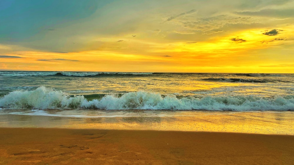 ocean waves crashing on shore during sunset