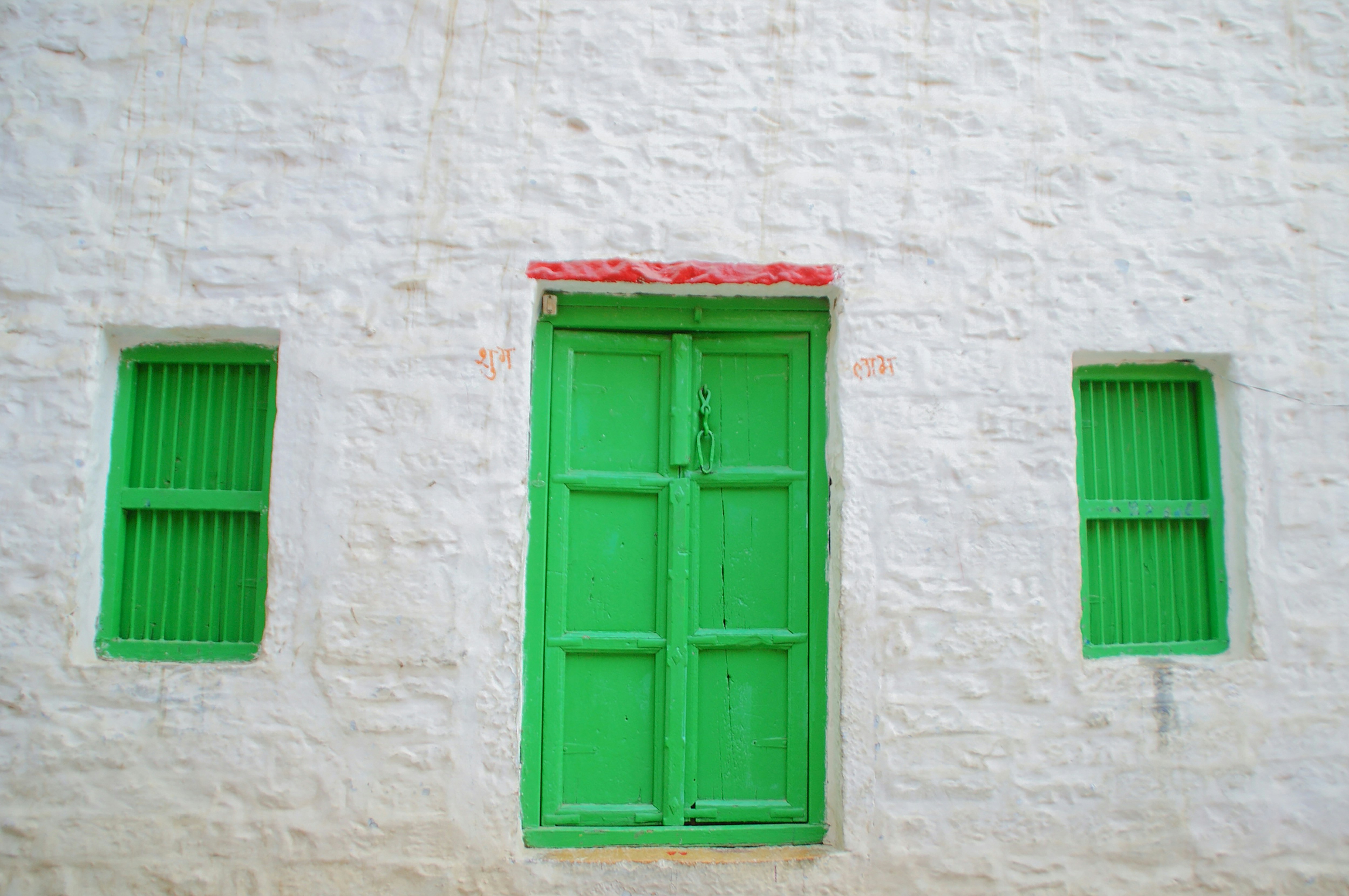 green wooden window on white concrete wall