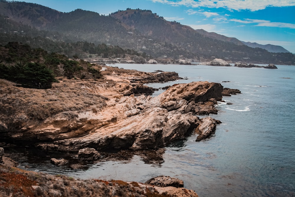 brown rock formation on body of water during daytime