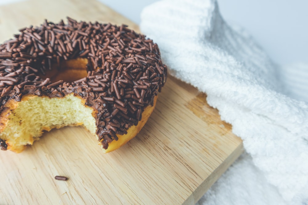 chocolate doughnut on brown wooden chopping board