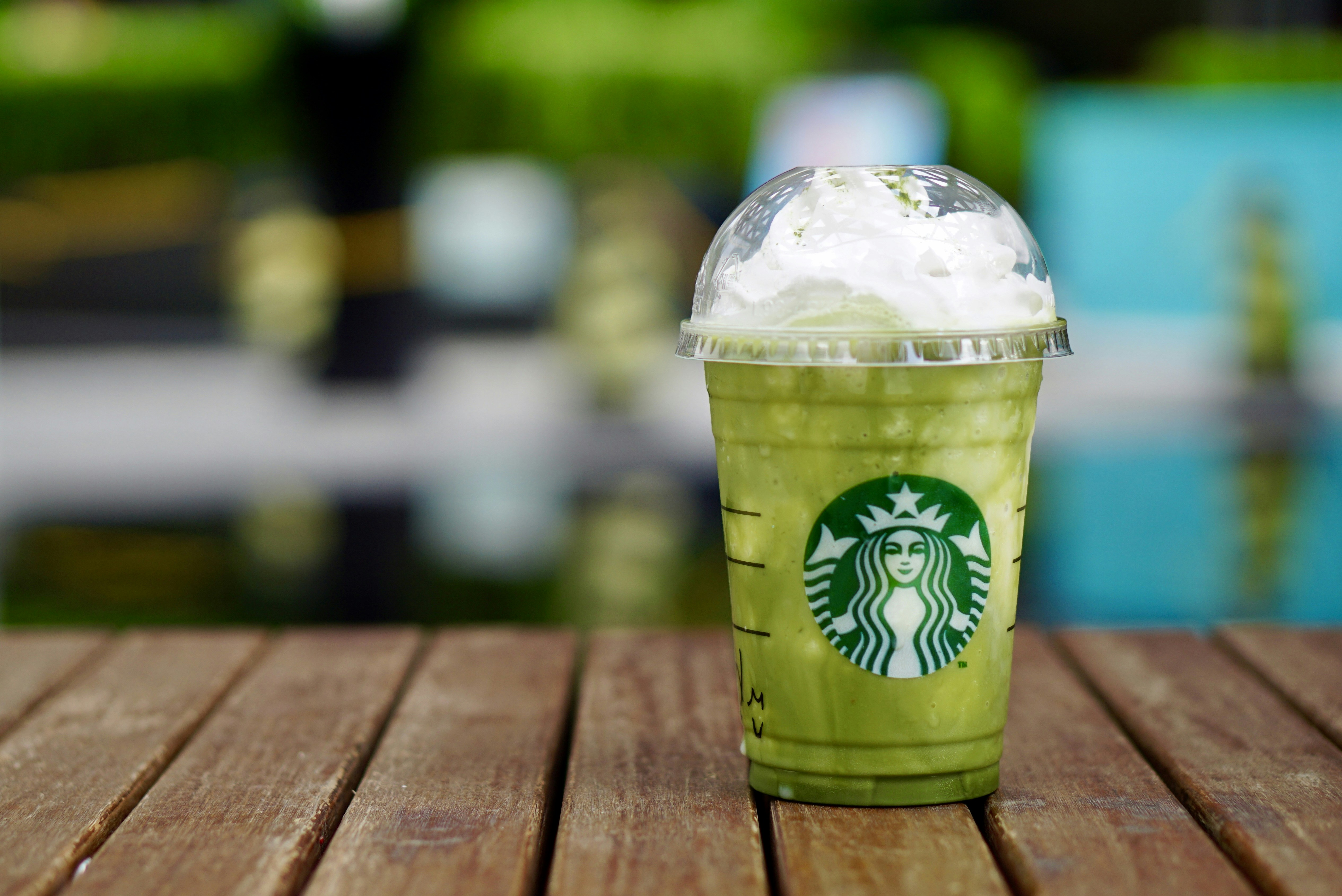 Taza de café Starbucks sobre mesa de madera marrón