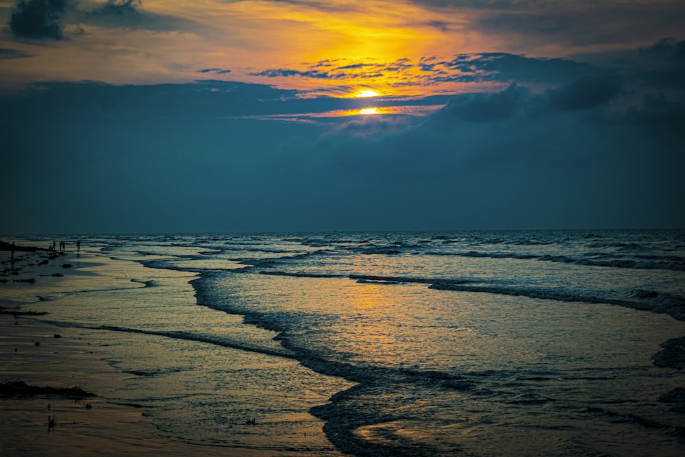 ocean waves crashing on shore during sunset