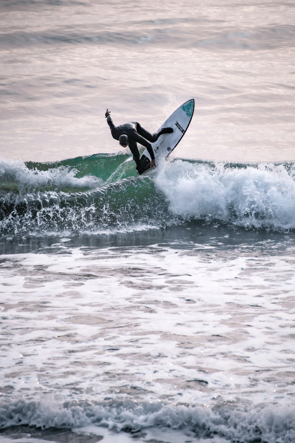 man surfing on sea waves during daytime