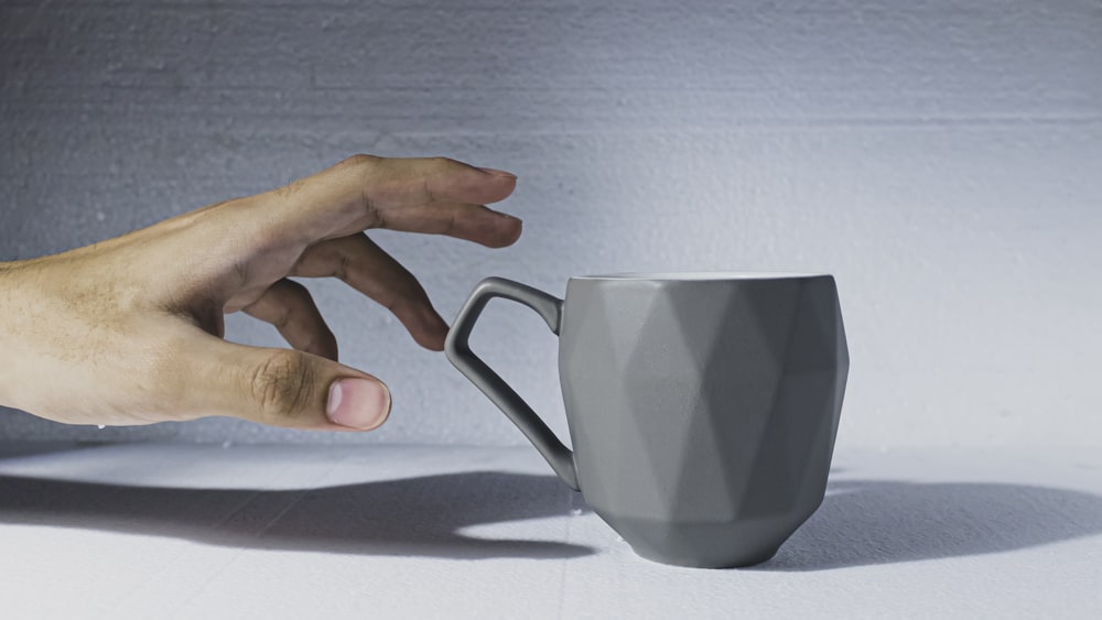 person holding white ceramic mug