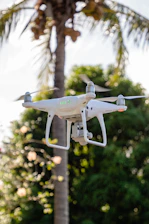 A close-up of a drone hovering near a pristine window, with lush Bahamian greenery reflected on the glass.
