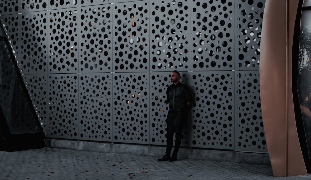 man in black jacket standing on gray concrete floor