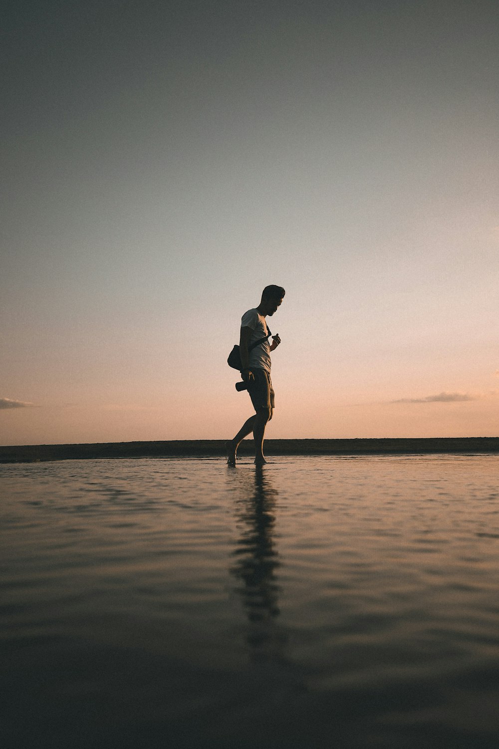 Silhouette einer Frau, die während des Sonnenuntergangs am Strand läuft