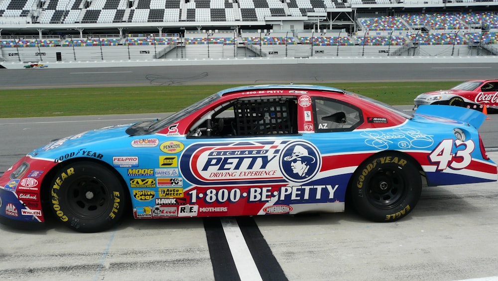 blue and red racing car on track during daytime