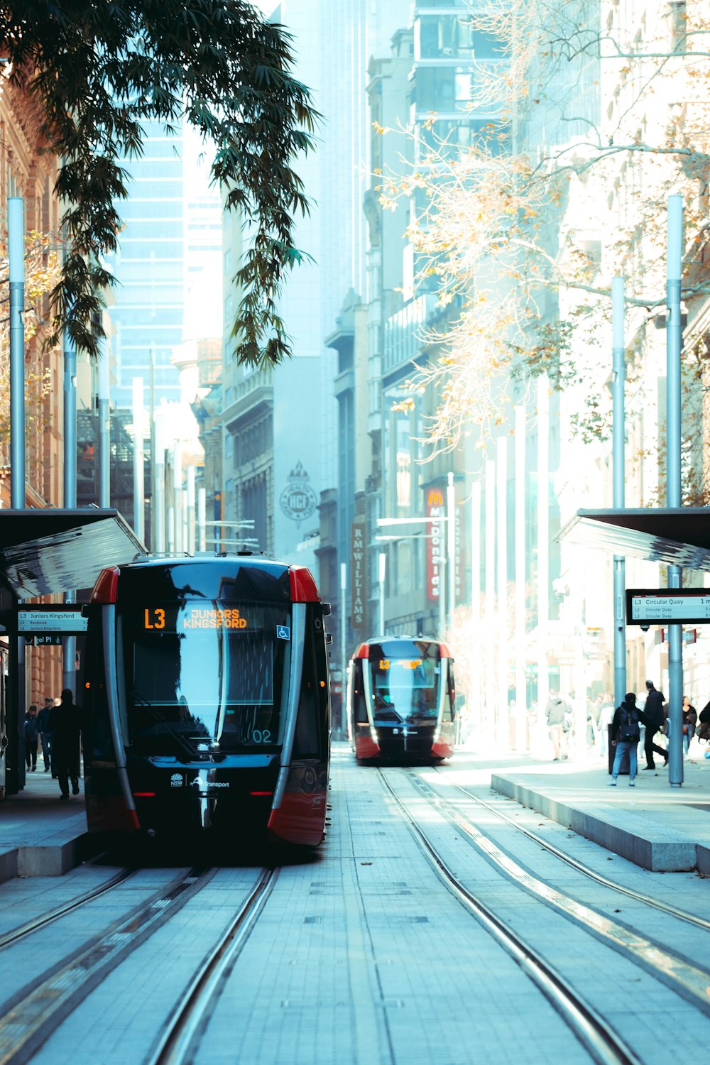 people walking on sidewalk near black train during daytime