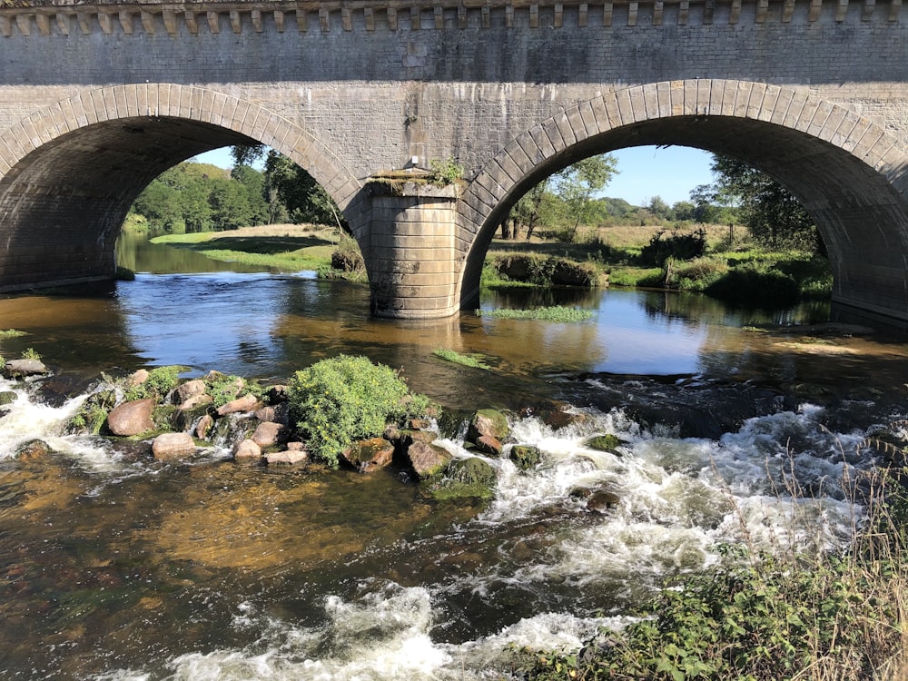昼間の川に架かる茶色のコンクリート橋