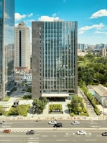 high rise building near green trees and road during daytime