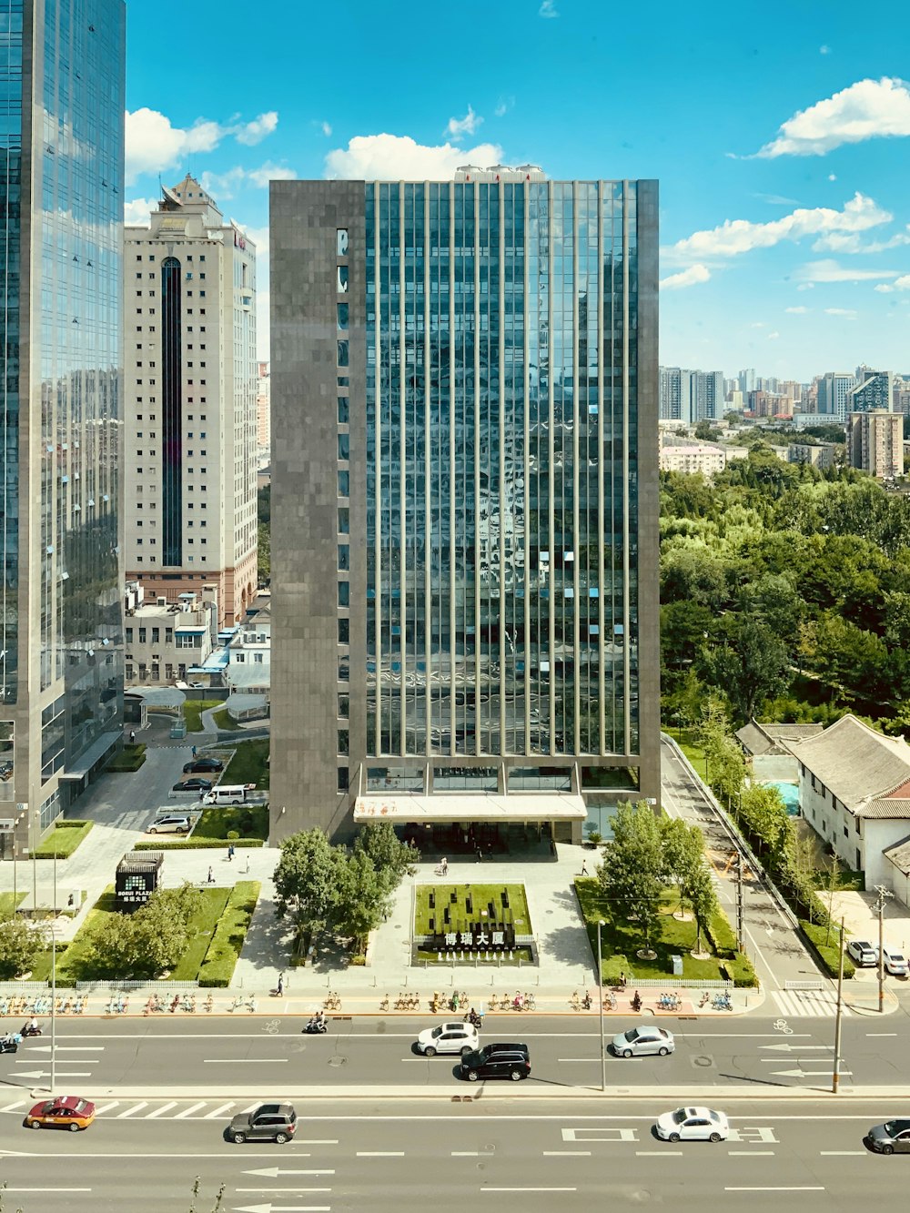 high rise building near green trees and road during daytime