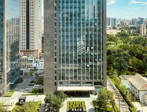 high rise building near green trees and road during daytime