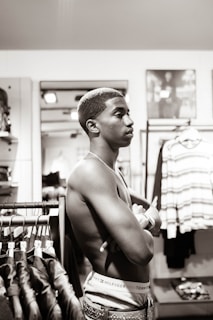 Young man browsing clothing racks in a bright, modern retail environment