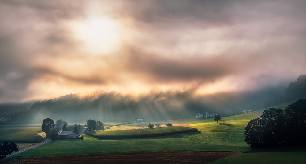 green grass field under cloudy sky during daytime