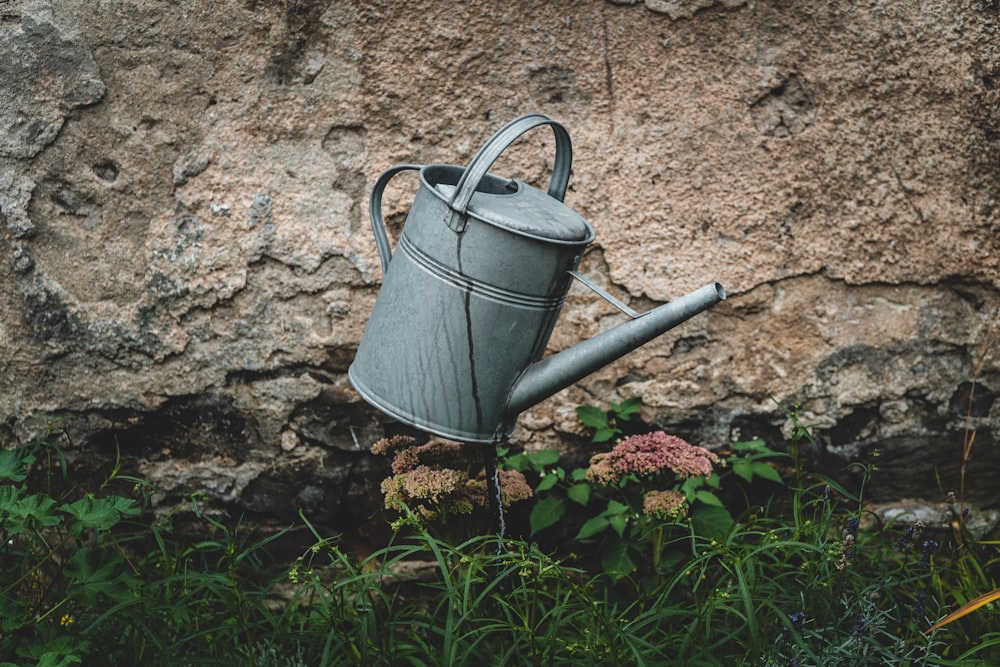 gray watering can on brown soil