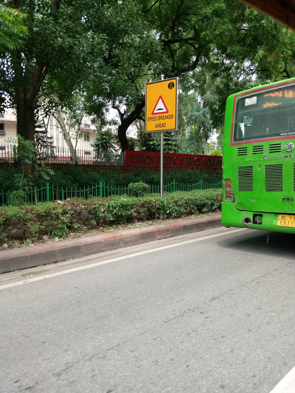 green bus on road during daytime