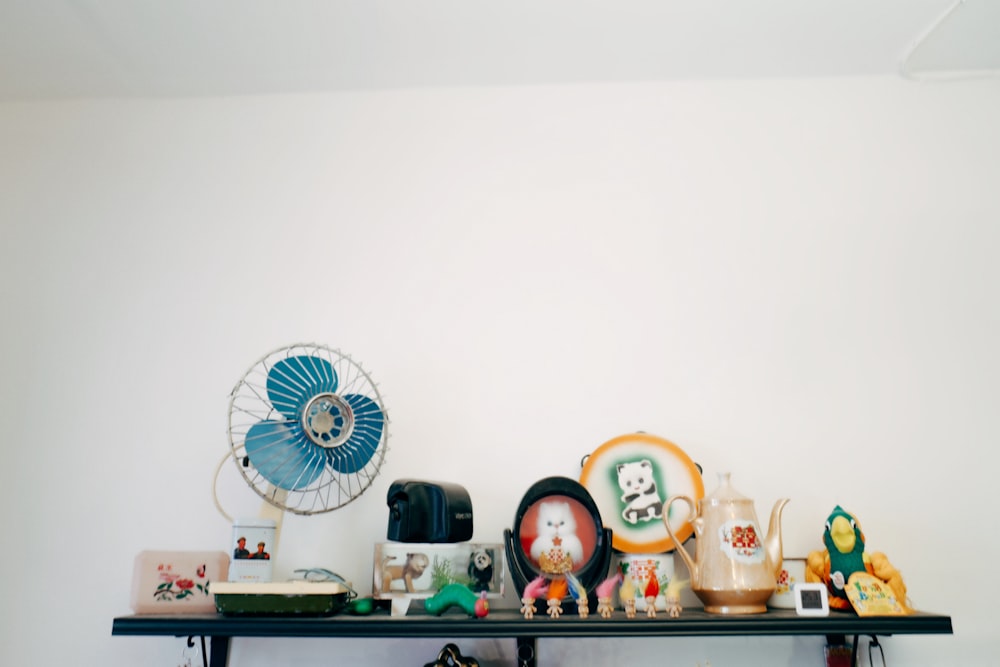 white and blue desk fan on white wooden table