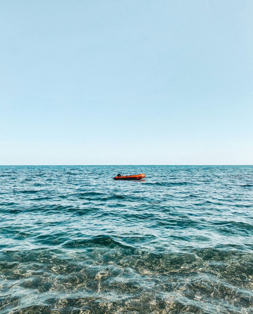 orange boat on sea during daytime