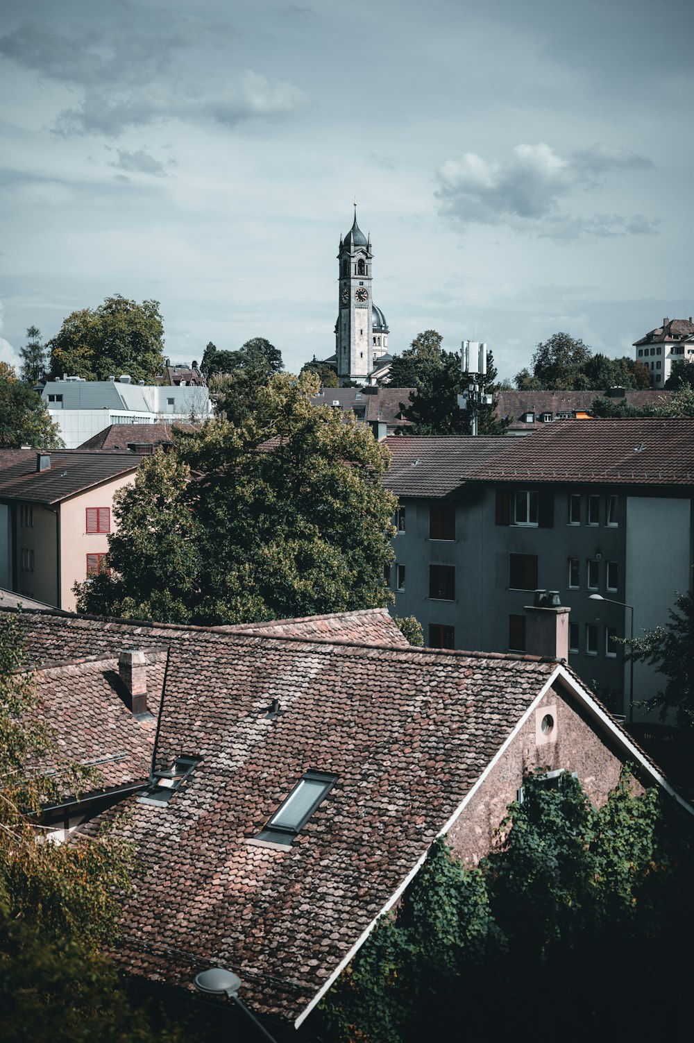 brown and white concrete building near green trees during daytime