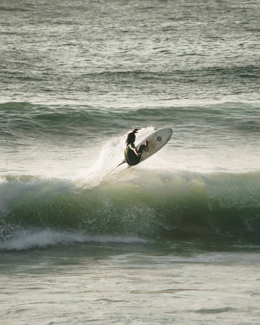 pessoa surfando nas ondas do mar durante o dia