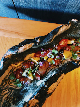 A vibrant close-up of a beautifully plated Asian fusion dish with fresh ingredients and colorful garnishes.