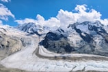 A panoramic landscape of glaciers under a clear blue sky.