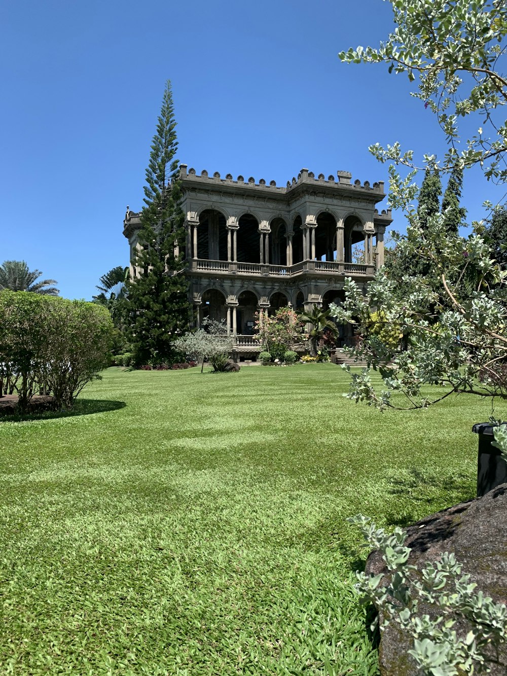 edificio in cemento marrone e bianco vicino al campo di erba verde sotto il cielo blu durante il giorno