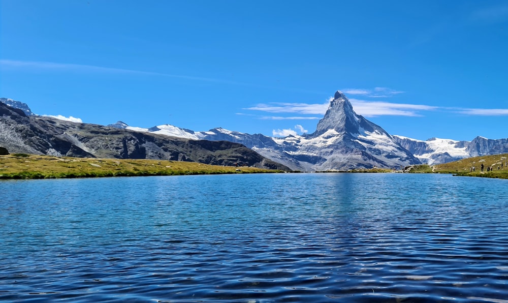 snow covered mountain near body of water during daytime