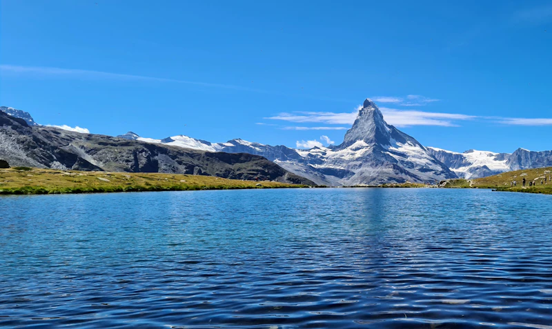 The Matterhorn rising beyond a frozen blue alpine lake near Zermatt