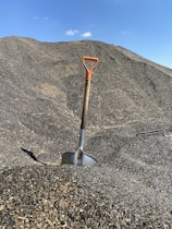 red and gray shovel on gray sand