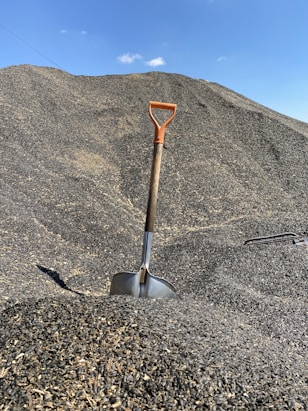 red and gray shovel on gray sand