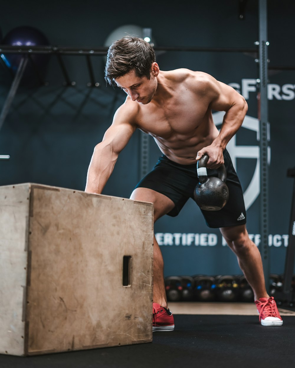 man in black shorts and boxing gloves doing push up